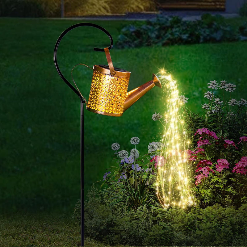 Watering can light lit at night beside a path