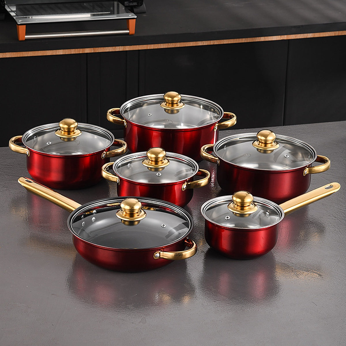 All six pots with their glass lids on a dark stone counter under a range hood