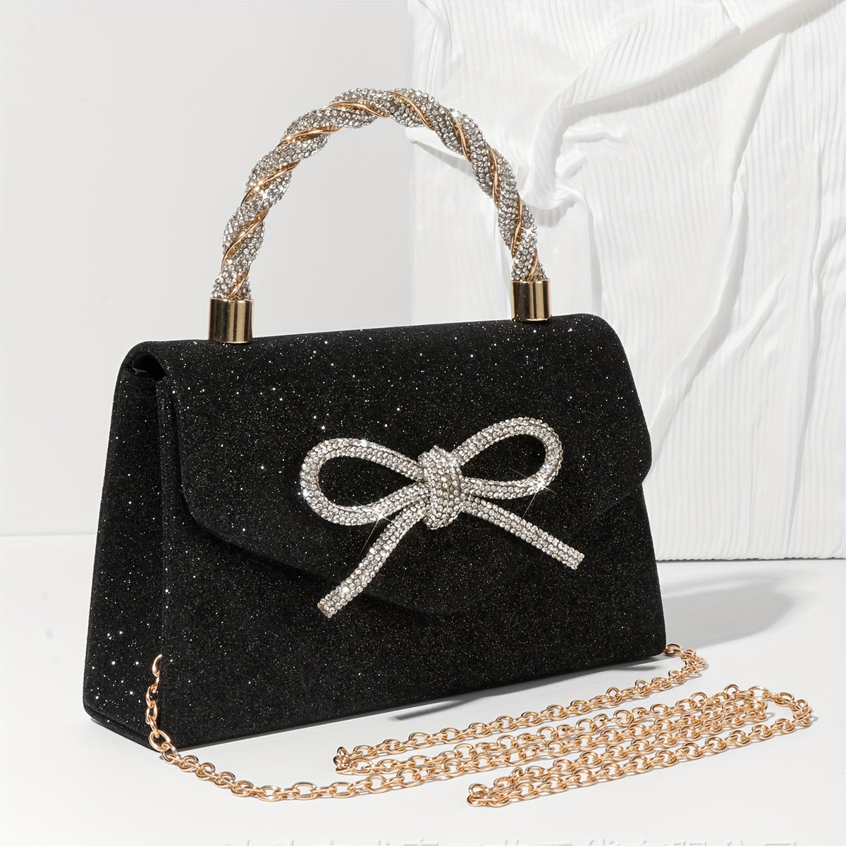 Black glitter evening clutch with rhinestone bow and chain strap