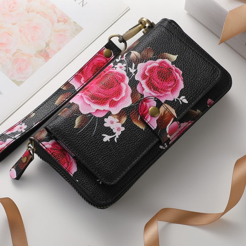 The wallet closed, showing the rose print, snap tab, zip pull, O-ring and matching wrist strap