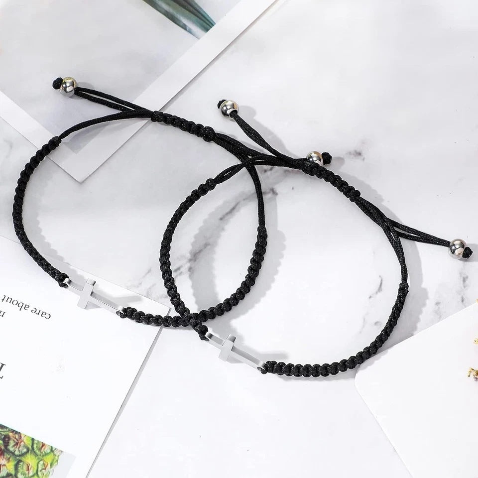 Two cross bracelets on a marble surface