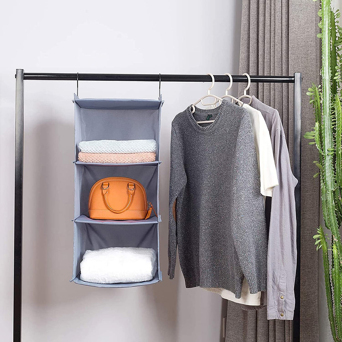 Organizer hung on a closet rail beside hanging clothes