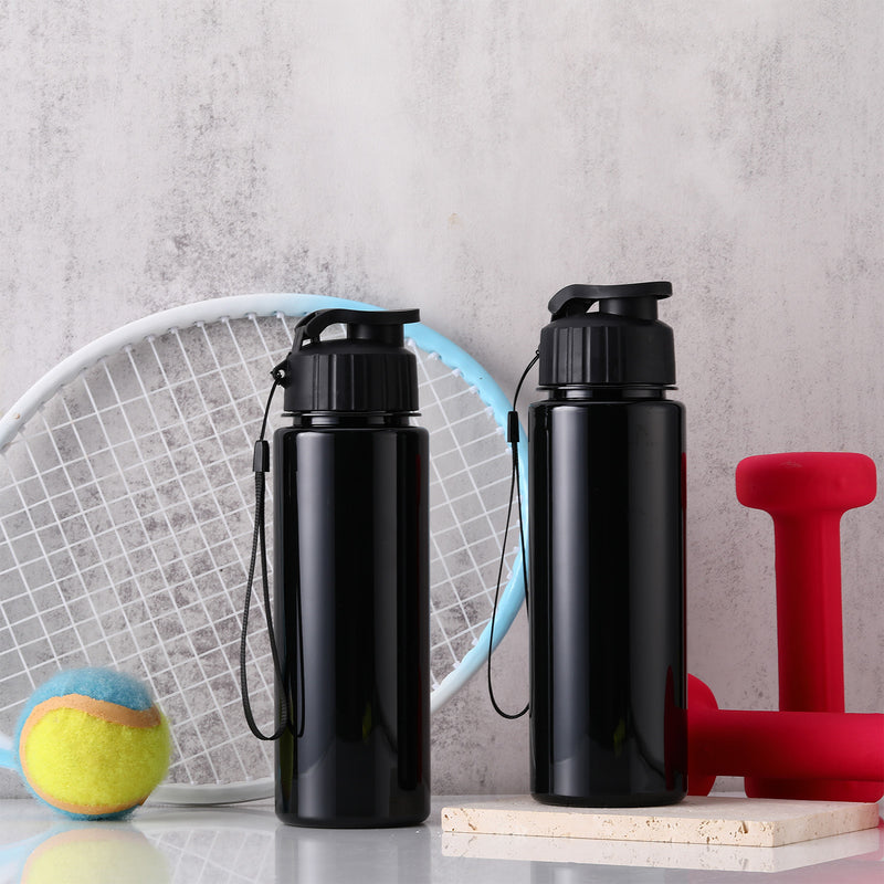 Two black water bottles with carry straps beside gym equipment
