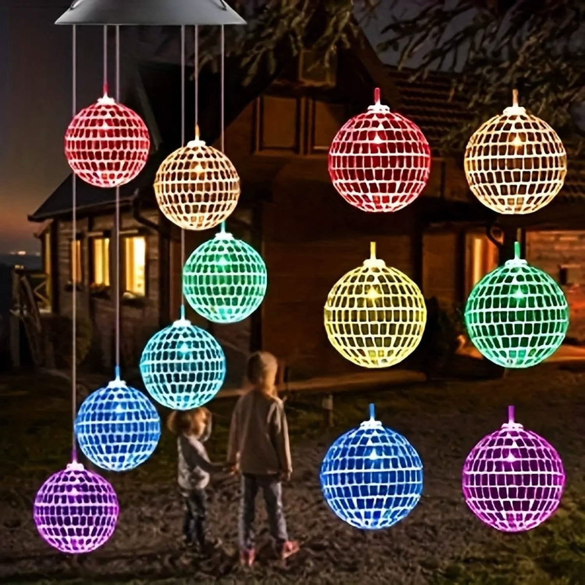 Six mirrored disco ball globes lit in pink, blue, green and gold outside a house at night