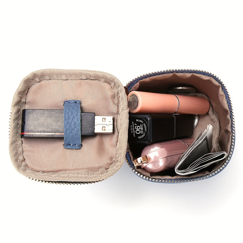 Purse open holding a card, cosmetics and a cable