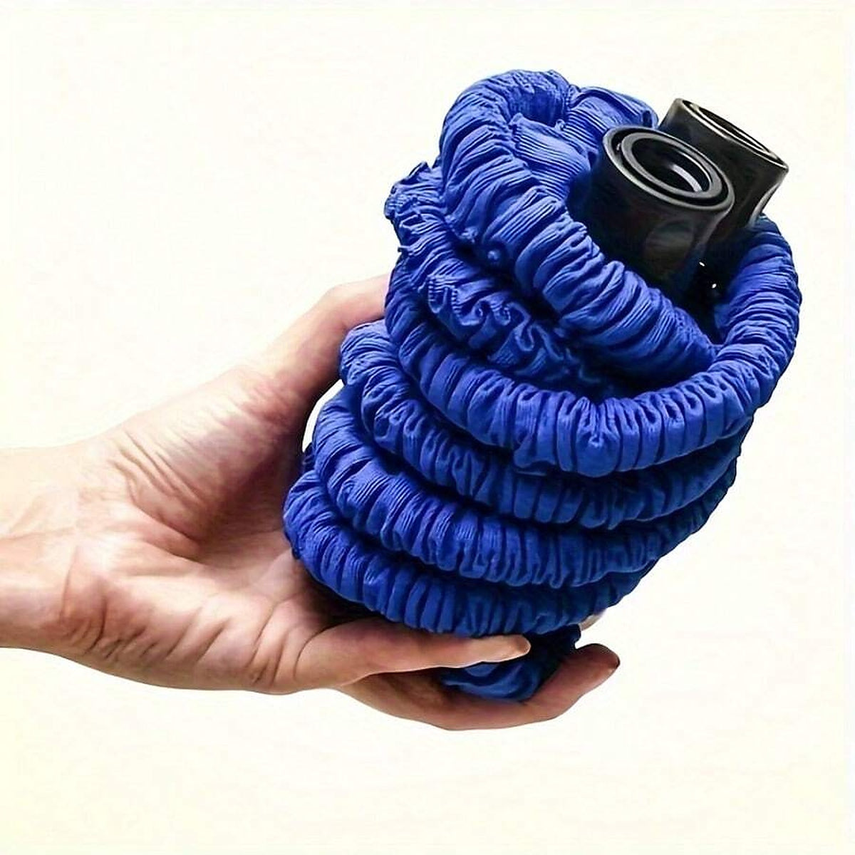 The contracted hose held in one hand, showing how light and compact it is
