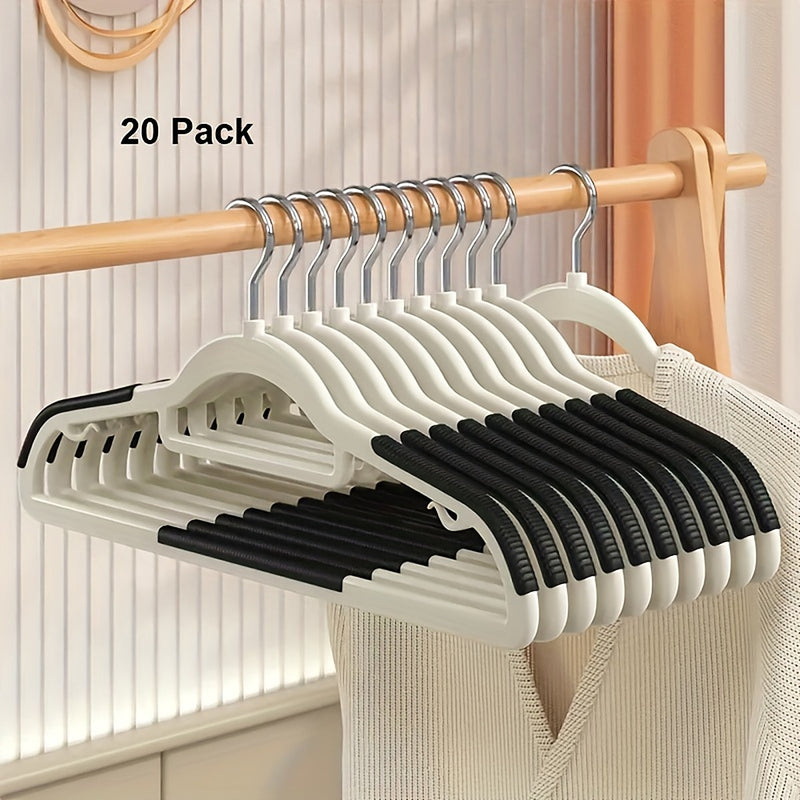 Twenty ivory hangers with black ribbed shoulder grips on a closet rail, labeled 20 Pack