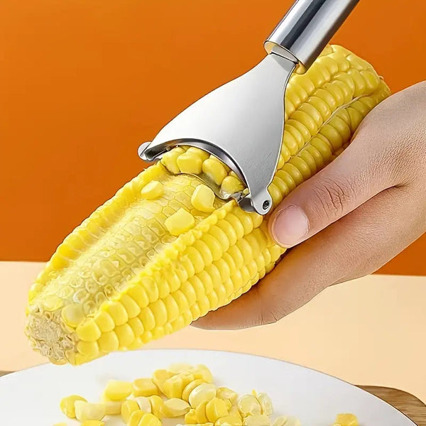 Closeup of a hand holding a Stainless Steel Corn Peeler removing corn kernels from the cob