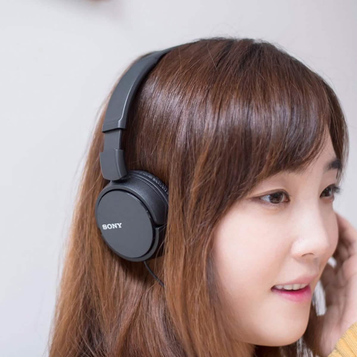 Woman wearing a black set of Sony MDRZX110 Stereo Headphones