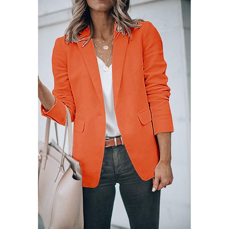 Woman holding her purse in the crook of her arm wearing a Cicy Bell Womens Casual Blazer, shown in orange