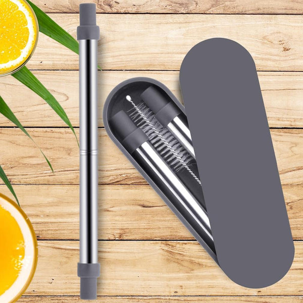 Collapsable Telescopic Reusable Drinkable Straw in grey on a wooden table next to its semi-open case next to some lemon slices