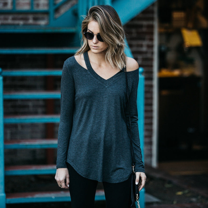 Woman in sun glasses standing with her hands to her side wearing a Cut Loose Long Sleeve Shirt in gray