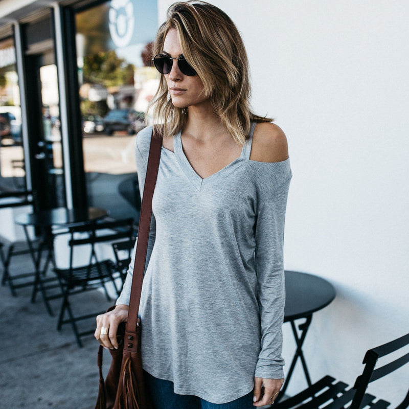 Woman in sun glasses standing with her hands to her side wearing a Cut Loose Long Sleeve Shirt in light gray