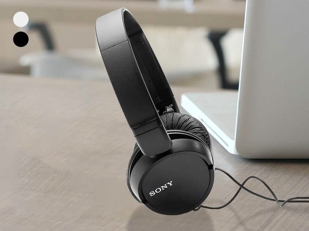 Black set of Sony MDRZX110 Stereo Headphones standing in front of a laptop computer