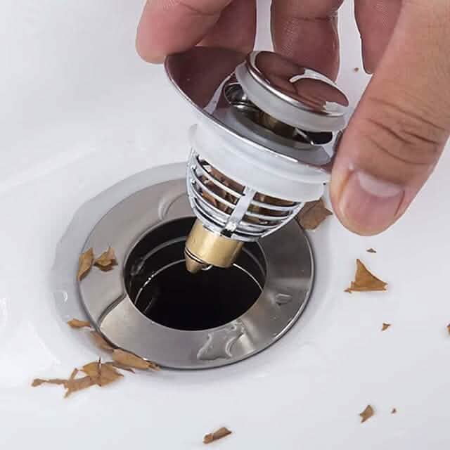 Hand placing a Universal Stainless Steel and Copper Pop-Up Bounce Core Basin Drain Filter, available at Dailysale