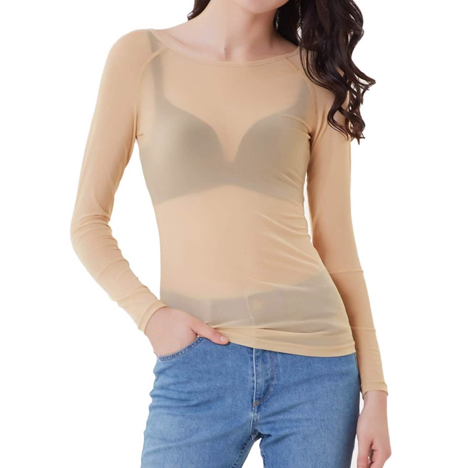 A woman standing looking forward with one hand in her pocket and the other one to the side, wearing Women's Long Sleeve Sheer Mesh Sheer Top in Nude