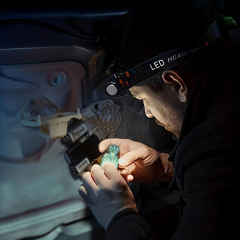 Headlamp in use for hands-free work under a car dashboard