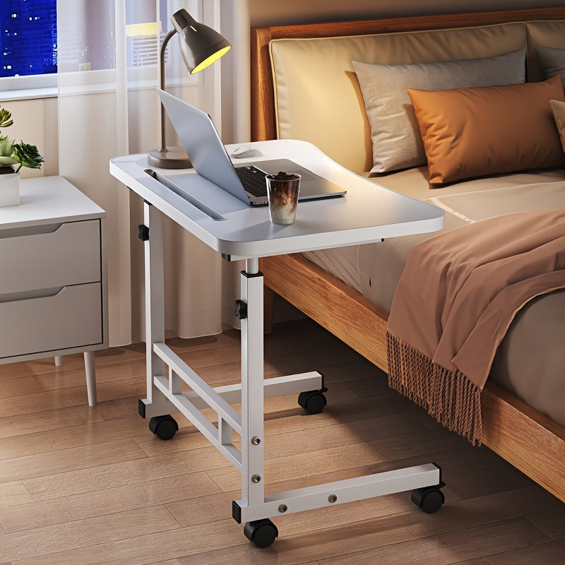 White height-adjustable mobile laptop desk beside a bed