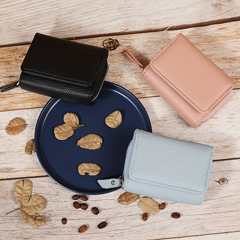 Black, dusty rose and sky blue wallets on a wooden surface