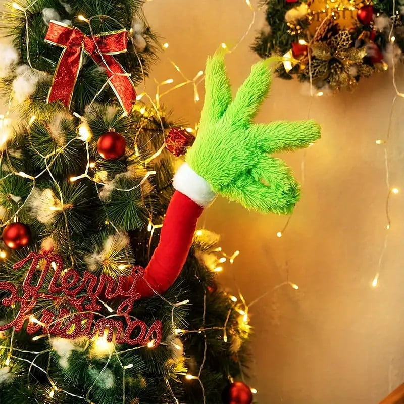The arm bent out of a lit Christmas tree beside a Merry Christmas sign