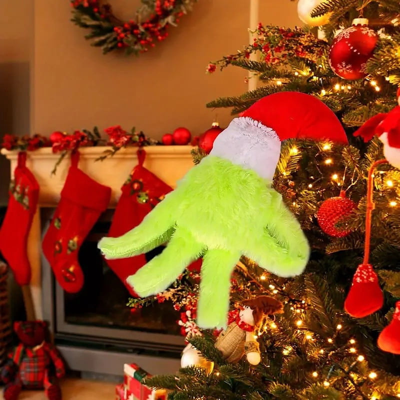 The hand reaching out over a mantel hung with red stockings, with a santa hat behind it