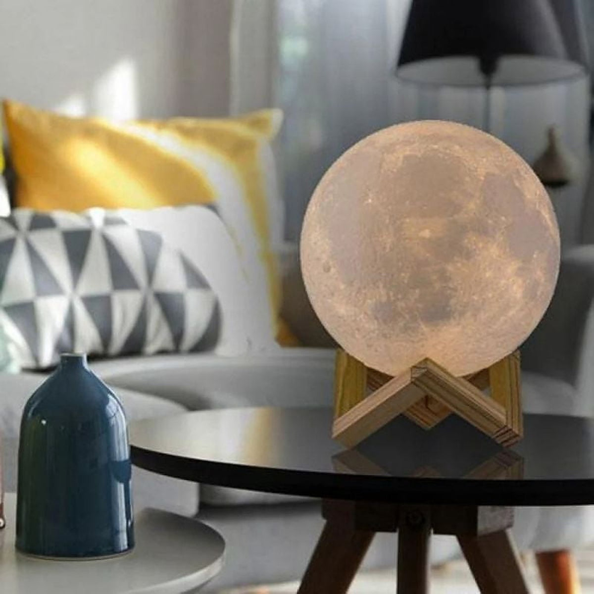 The lamp on a glass side table in a living room, lit a soft warm white