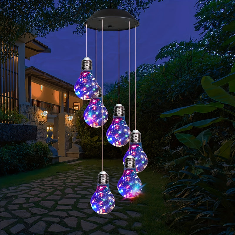 Lit in color hanging over a garden path at dusk with a house behind