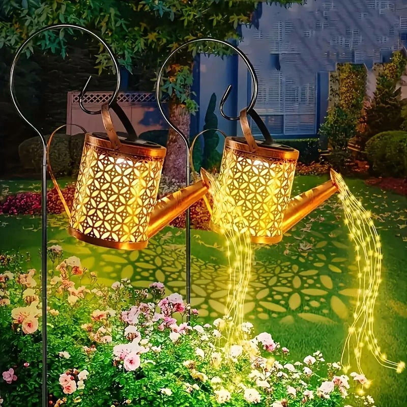 Solar watering can lights pouring warm white LED strands in a garden