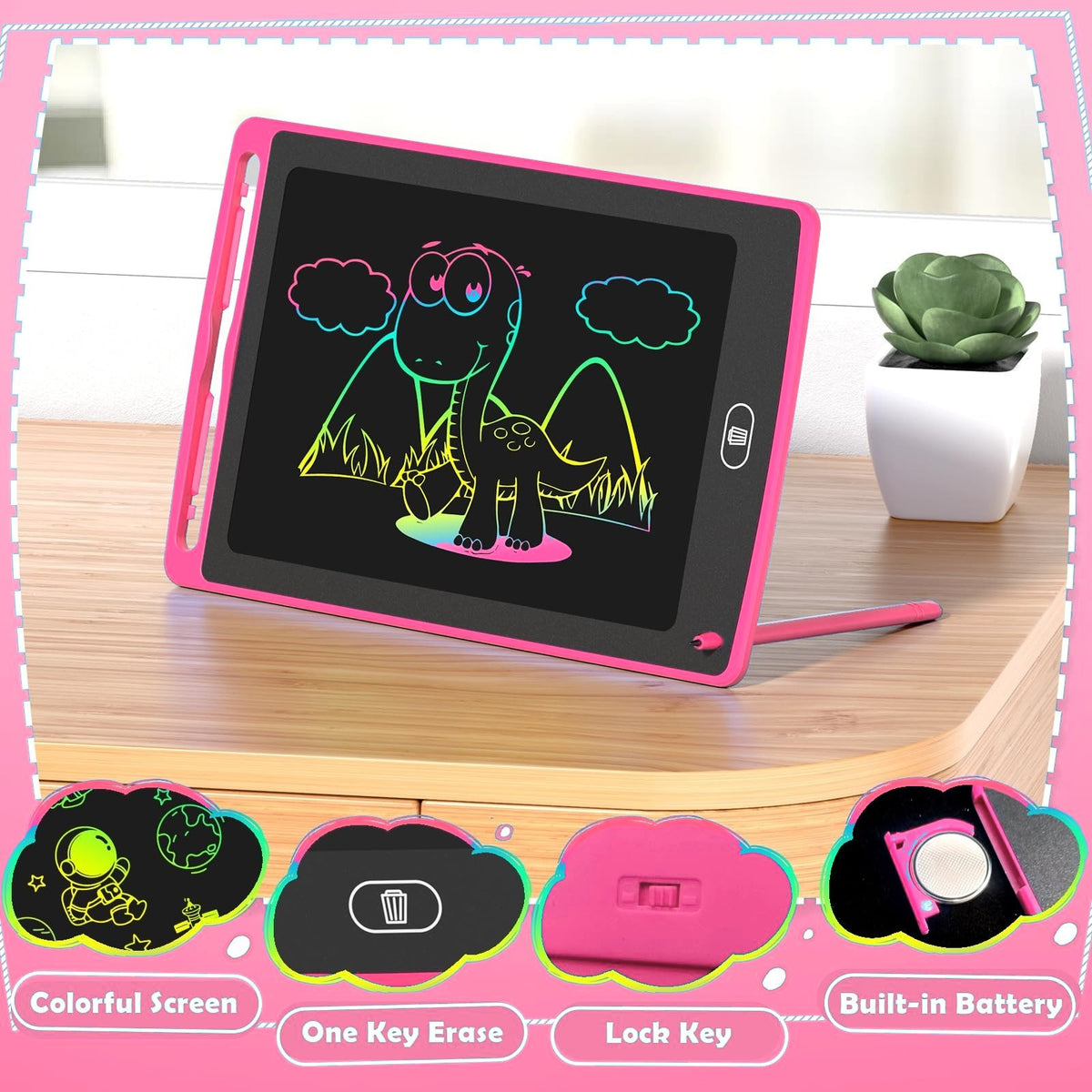 Pink LCD writing tablet standing on a desk with a rainbow dinosaur drawing, stylus and erase button