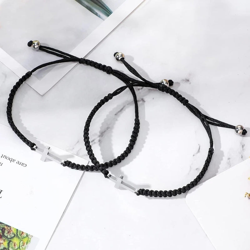Two cross bracelets on a marble surface