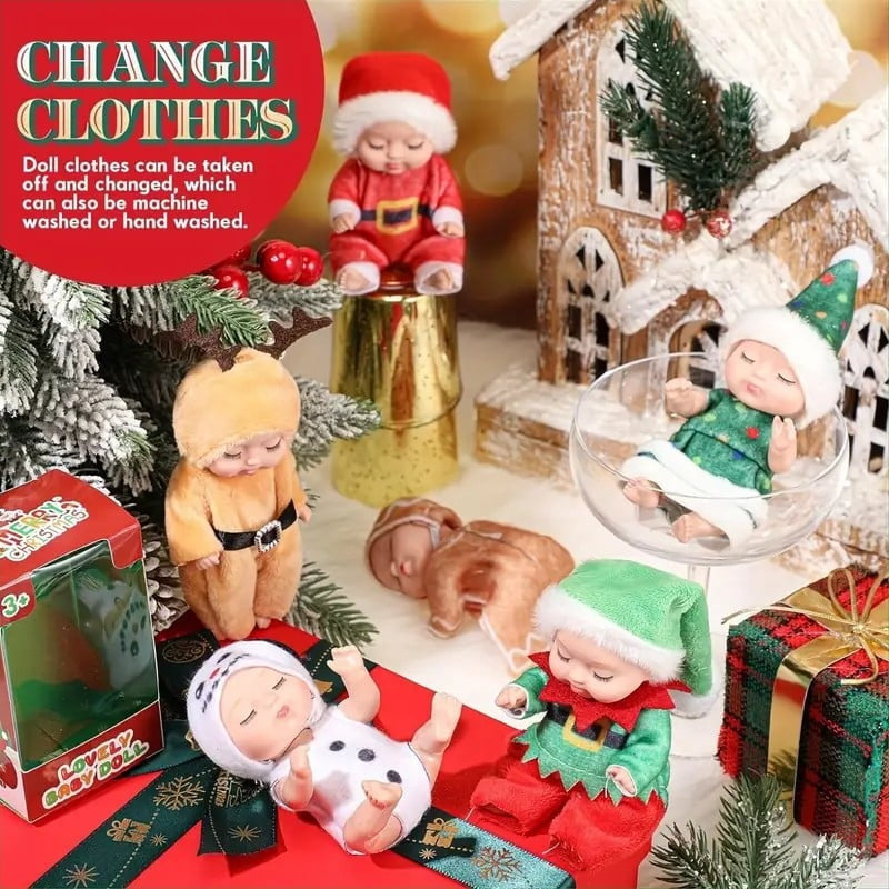 Dolls in Christmas outfits staged with a gingerbread house, gifts and the retail box