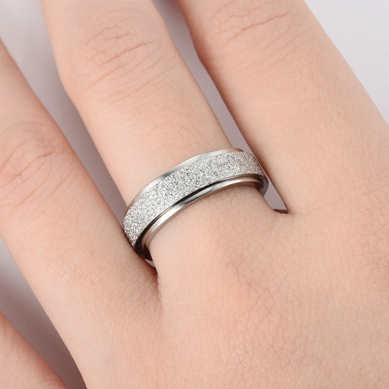 Silver spinner ring worn on a hand