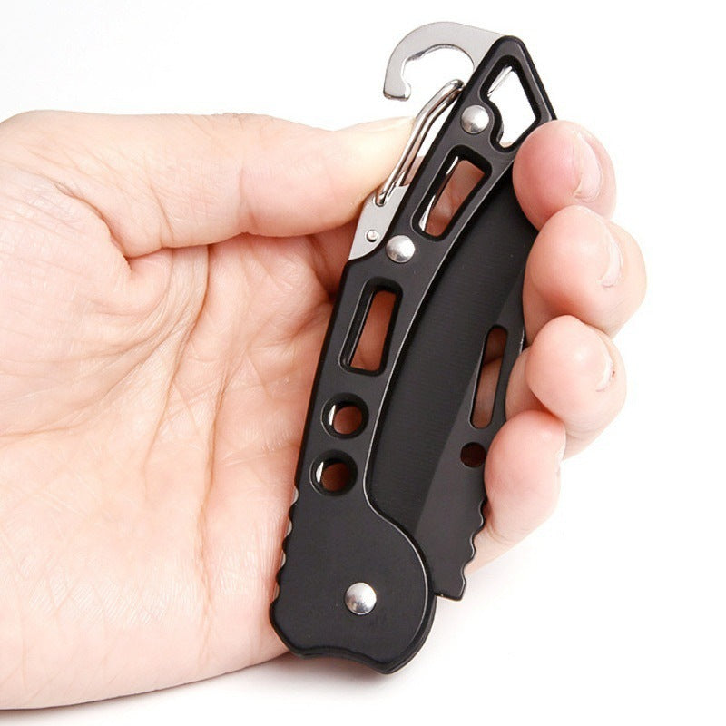 Folding pocket knife held in a hand showing its compact size