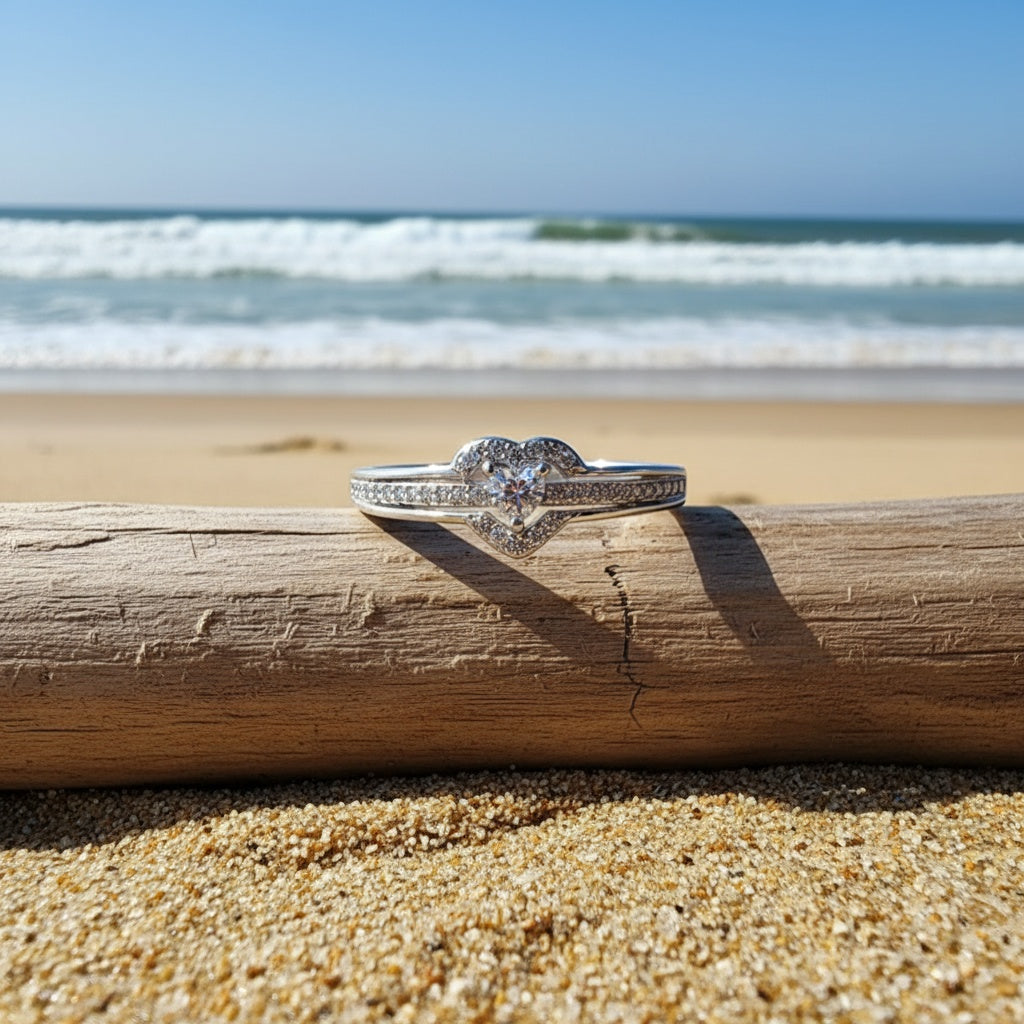 Silver heart ring on driftwood by the sea