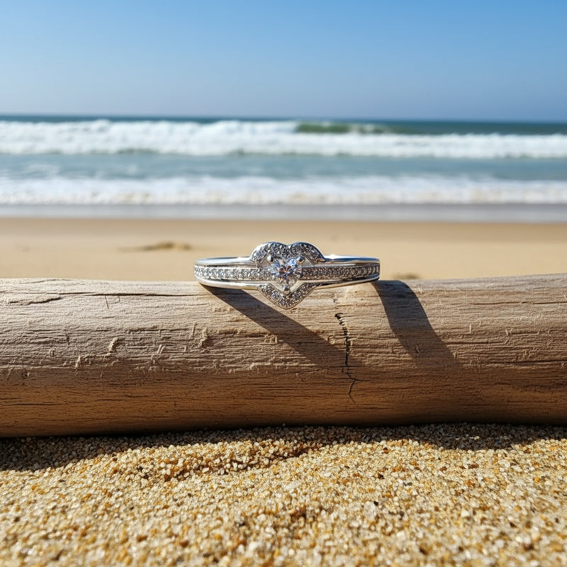 Silver heart ring on driftwood by the sea
