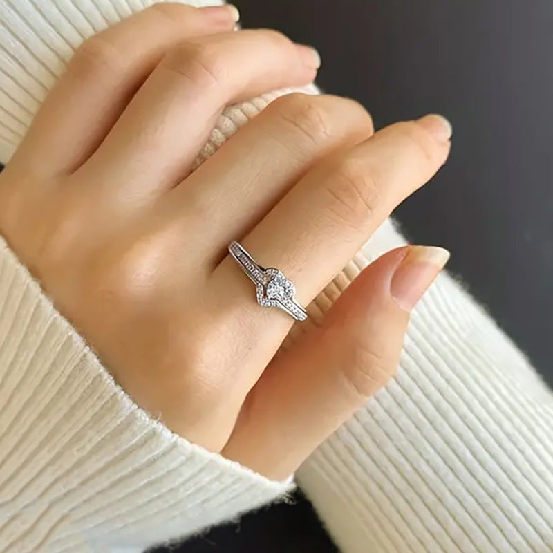 Silver heart ring worn on a hand