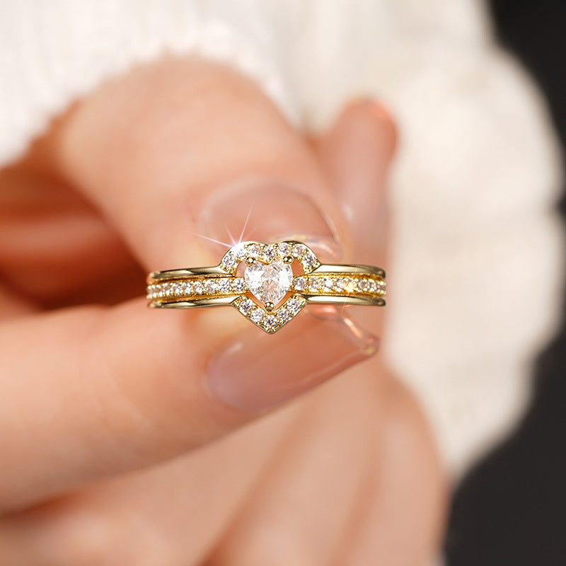 Gold-tone heart ring with sparkling zirconia worn on a finger