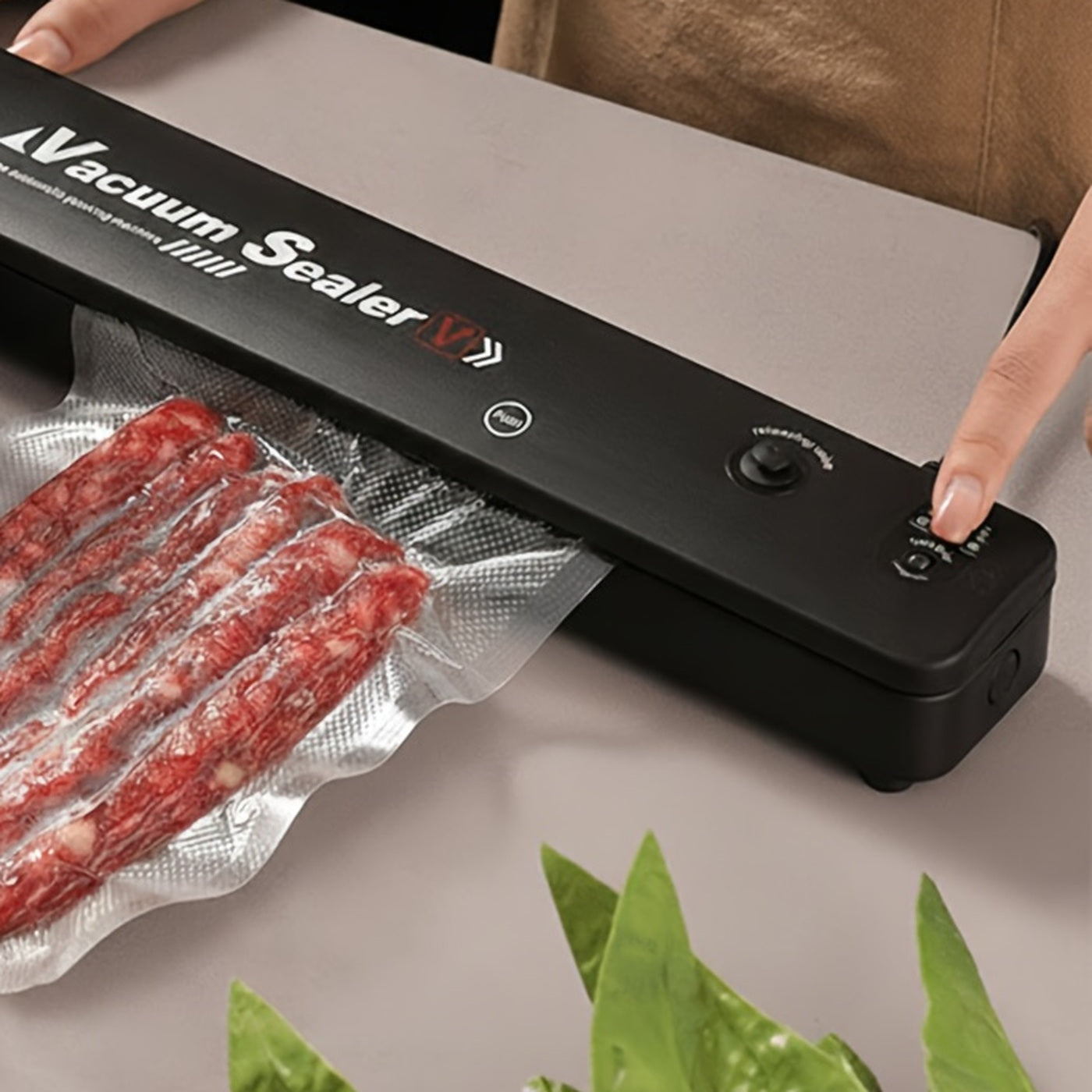 Black vacuum sealing machine sealing a bag of food on a kitchen counter