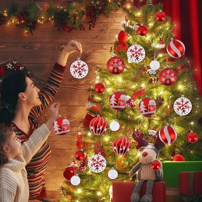 Hanging the ornaments on a lit tree