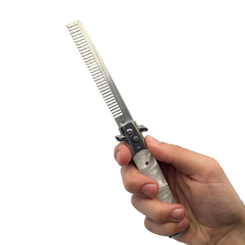 Closeup of a hand holding a 4" Stiletto Automatic Comb Knife, shown in the open position