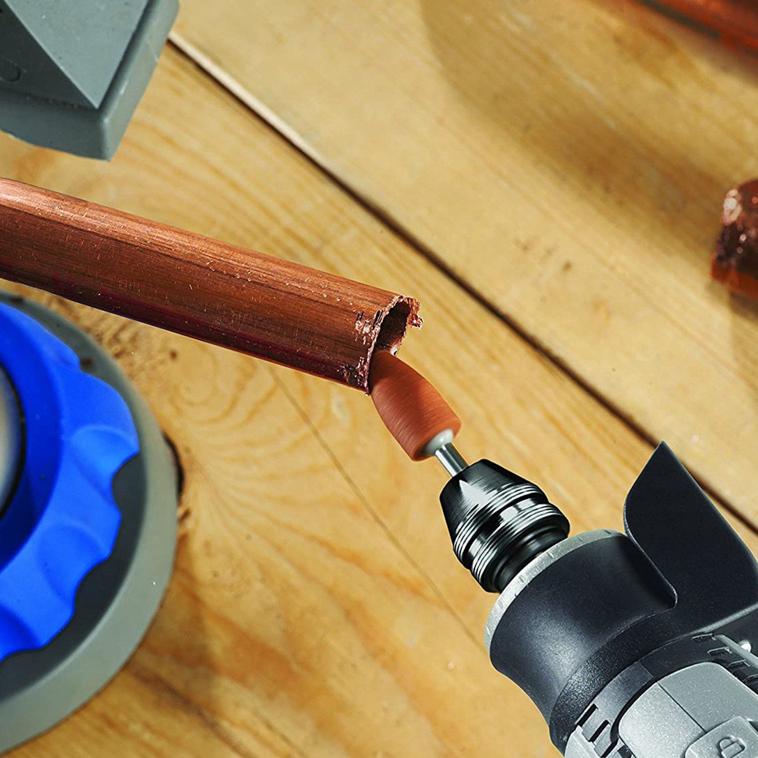 Rotary Dremel tool filing the edge of a metal pipe using one of the tools from the 228-Piece Rotary Dremel Accessory Tool Kit