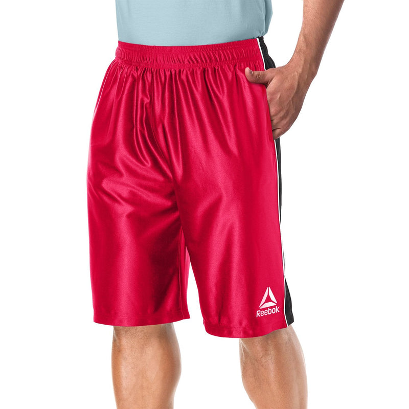Man with one hand in his pocket modelling the Reebok Men's Two Toned Athletic Performance Dazzle Shorts With Pockets in red