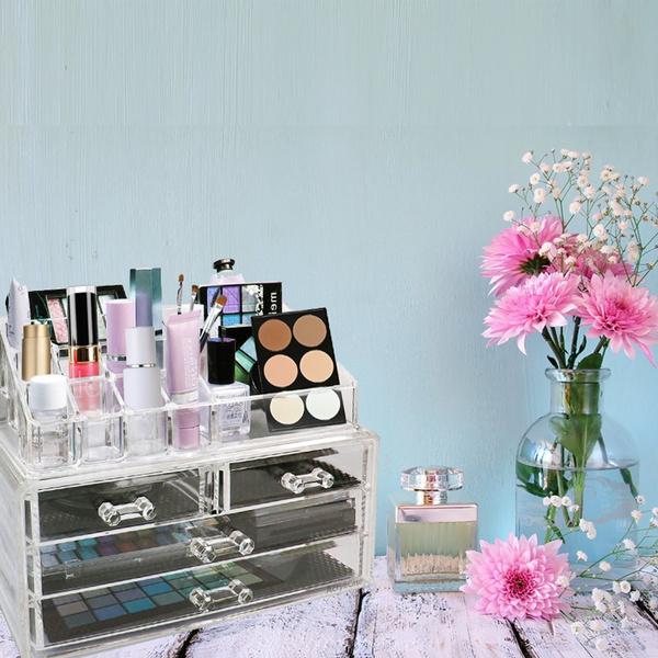 Acrylic Makeup Organizer Cosmetic Jewelry Display Box full of makeup products displayed on top of a table next to a vase with flowers