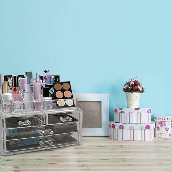 Acrylic Makeup Organizer Cosmetic Jewelry Display Box full of makeup products displayed on top of a woden table next to a small picture frame