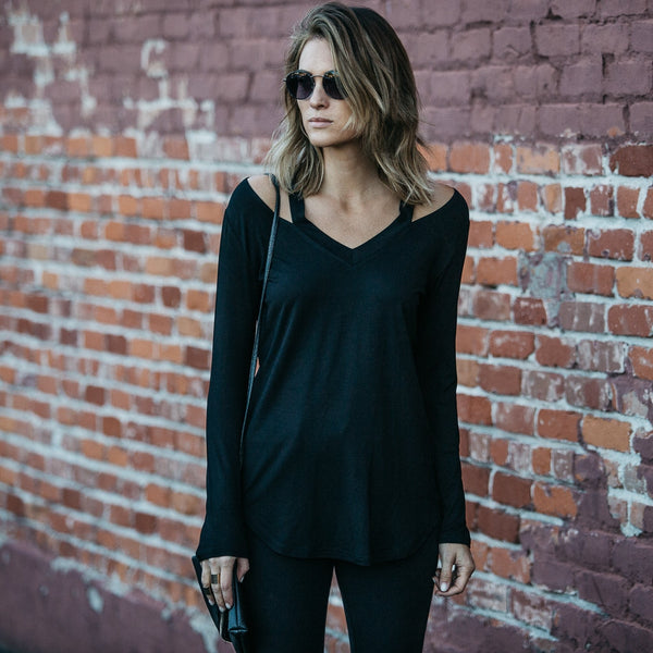 Woman in sun glasses standing with her hands to her side wearing a Cut Loose Long Sleeve Shirt in black