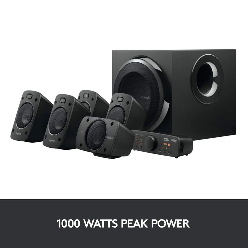 Angled view of Logitech Z906 5.1 Surround Sound Speaker System - THX, Dolby Digital and DTS Digital Certified - with a sign underneath showing a peak power of 1,000 watts