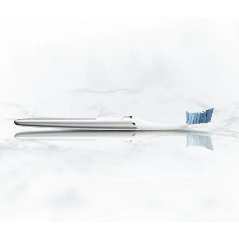 A white Oral-B Clic Manual Toothbrush lying on a white counter surface